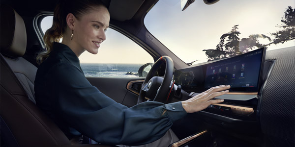 BMW Elektromodelle, BMW i5 eDrive40 Limousine, parkend vor moderner Architektur