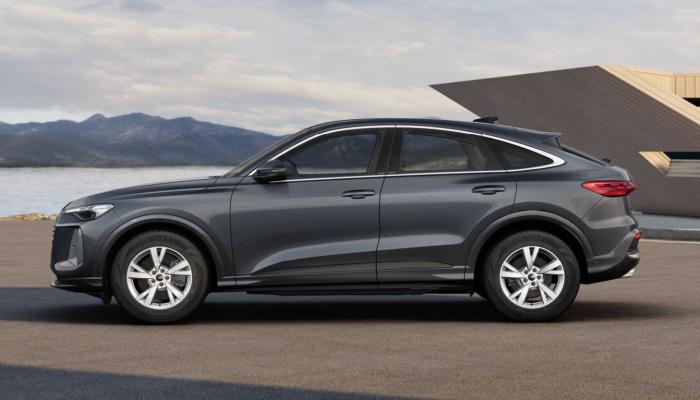 Der neue Audi Q5 Sportback vor einem modernen Gebäude an der Meeresküste.