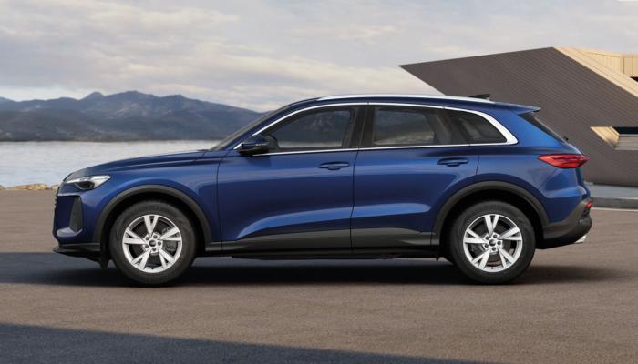 Der neue Audi Q5 SUV vor einem modernen Gebäude an der Meeresküste.