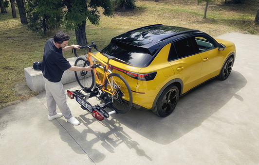 Mann befestigt ein Rennrad am Heck des neuen T-Roc