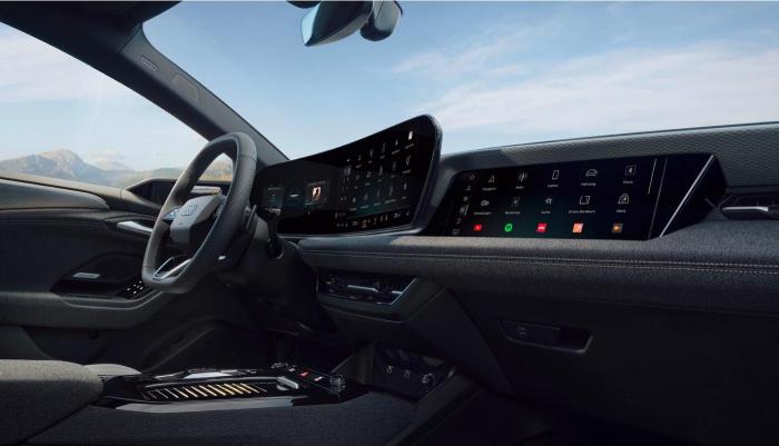 Das Cockpit eines Audi A6 e-tron Modells aus Beifahrersicht. Die Kamera konzentriert sich auf das Beifahrer-Display, das Panorama-Display und das 3-Speichen-Sportlenkrad.