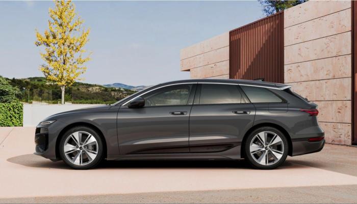 Der Audi A6 Avant e-tron vor einem modernen Gebäude in mediterraner Landschaft. Zu sehen ist die im 180-Grad-Winkel aufgenommene Fahrerseite.