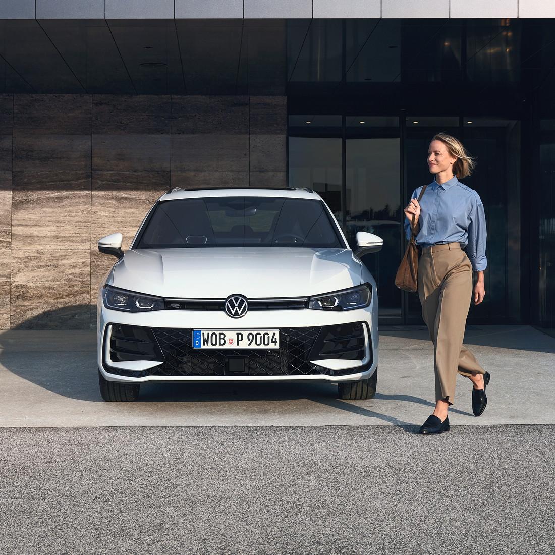 Frau im Business-Look läuft an einem geparkten Passat R-Line vorbei