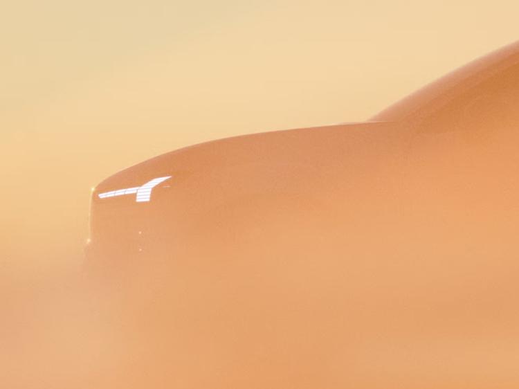 Thors Hammer-Scheinwerfer leuchtet durch orangefarbenen Nebel, wobei die Umrisse des EX60 nur leicht erkennbar sind