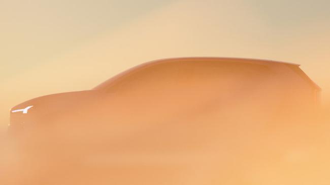 Thors Hammer-Scheinwerfer leuchtet durch orangefarbenen Nebel, wobei die Umrisse des EX60 nur leicht erkennbar sind