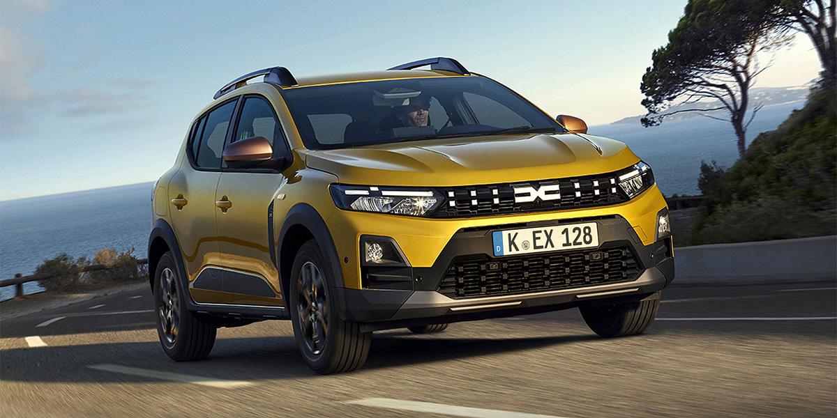 Gelber Sandero Stepway fahrend auf einer Küstenstraße.