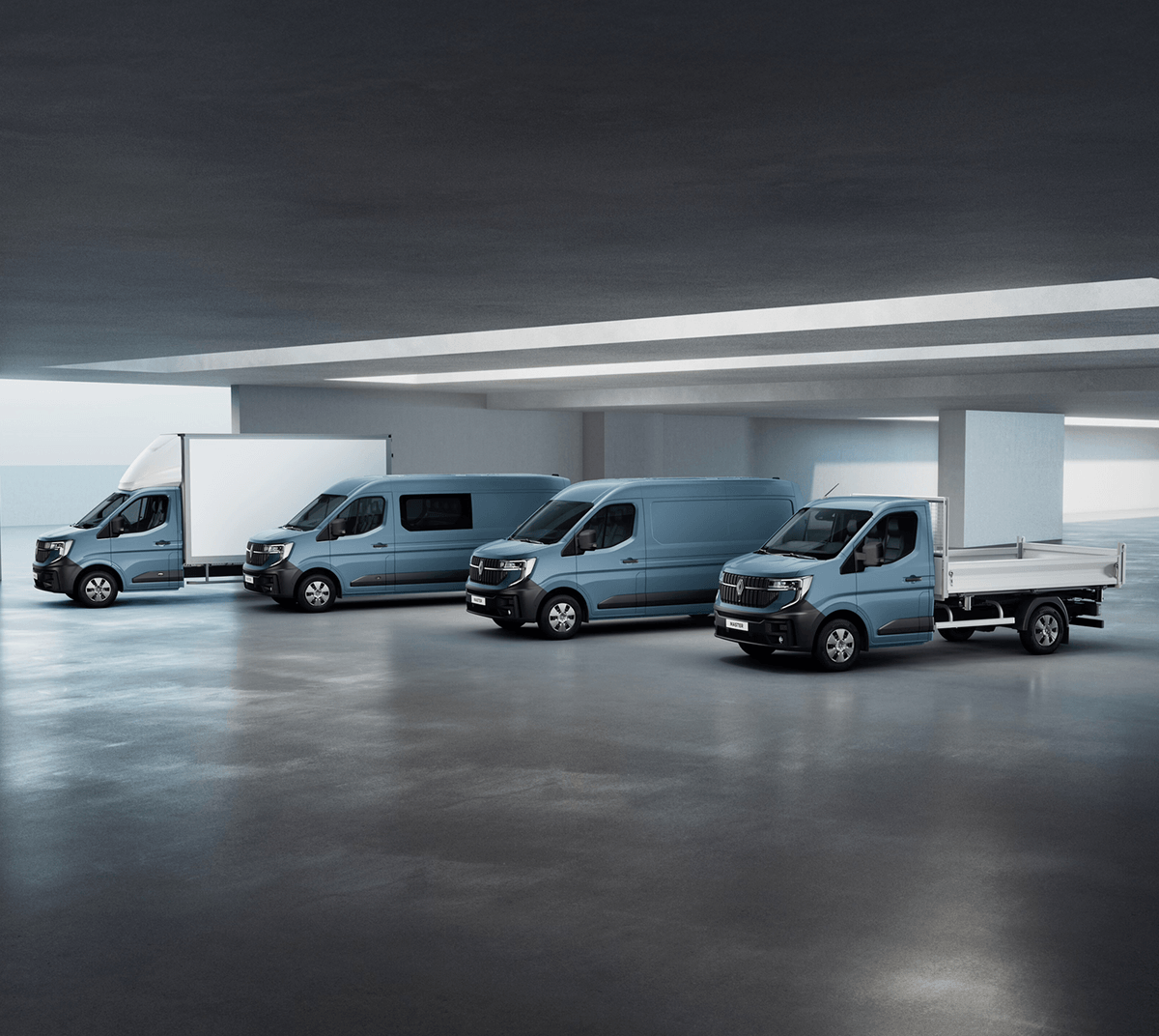 Bild zeigt mehrere Renault‑Nutzfahrzeuge, darunter Kastenwagen und Pritschenfahrzeug, in einer modernen Halle