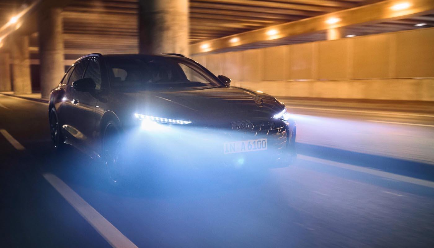 Ein Audi A6 Avant fährt durch einen nächtlichen Tunnel. Deutlich zu erkennen: die Lichtkegel der digitalen Matrix LED-Scheinwerfer.