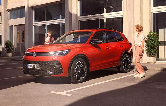 Zwei Personen gehen auf den geparkten Tiguan zu