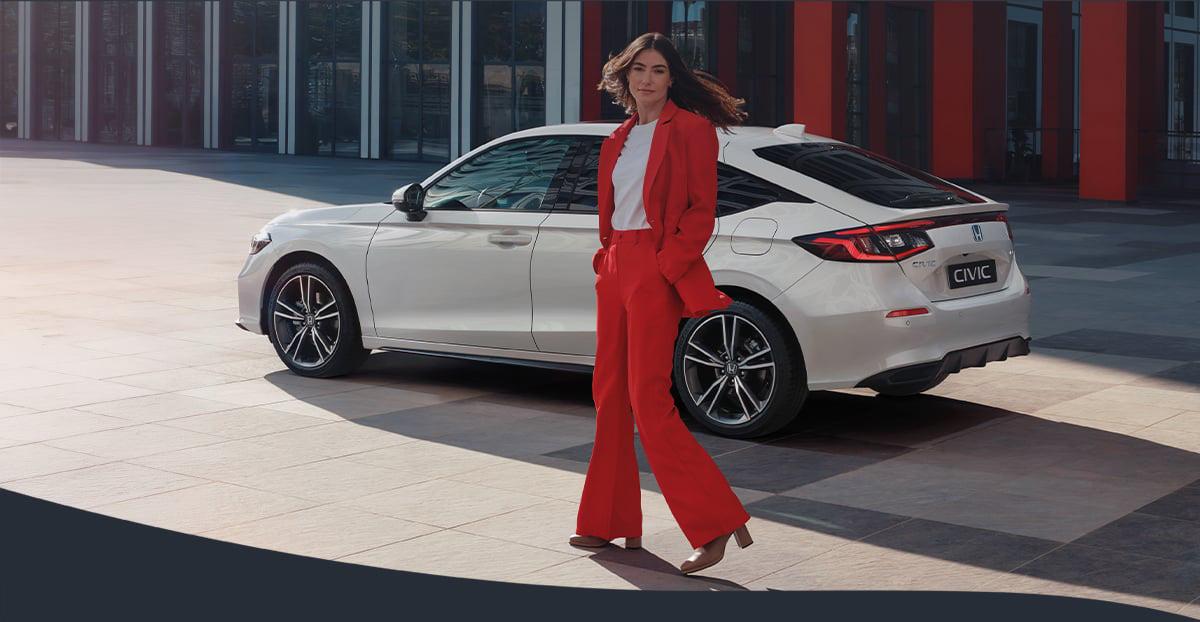 Honda Civic e:HEV Elegance – weiße Limousine, eine Person steht daneben