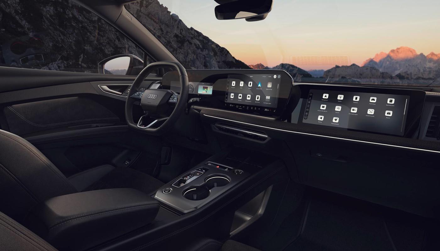 Blick in das Cockpit des Audi Q4 e-tron. Man sieht das Doppelspeichen-Sportlederlenkrad, die Mittelkonsole, das MMI-Touchdisplay und das Beifahrerdisplay.